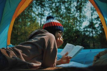 A girl with a book for knowing the ways of how to keep air mattress from deflating