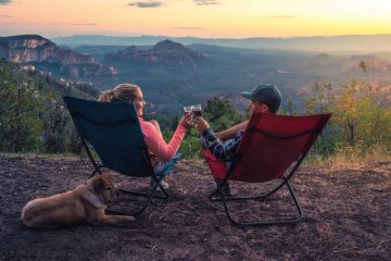 A couple sit on a trail with the best camping chair with back support