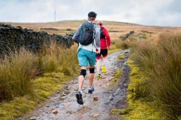 two-man running on the trail with the best knee brace for hiking
