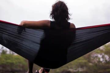 A Man Sits on Best Camping Hammocks for Big Guys